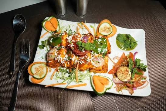 A colorful Indian appetizer platter served with chutney and salad
